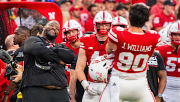 Oct 5, 2024; Lincoln, Nebraska, USA; Nebraska Cornhuskers assistant coach Terrance Knighton and defensive lineman James Williams (90) celebrate after a turnover on downs against the Rutgers Scarlet Knights during the fourth quarter at Memorial Stadium. Mandatory Credit: Dylan Widger-Imagn Images