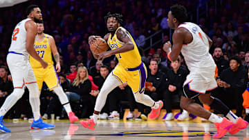 Mar 6, 2025; Los Angeles, California, USA; Los Angeles Lakers forward Dorian Finney-Smith (17) moves the ball against New York Knicks center Karl-Anthony Towns (32) and forward OG Anunoby (8) during the second half at Crypto.com Arena. Mandatory Credit: Gary A. Vasquez-Imagn Images