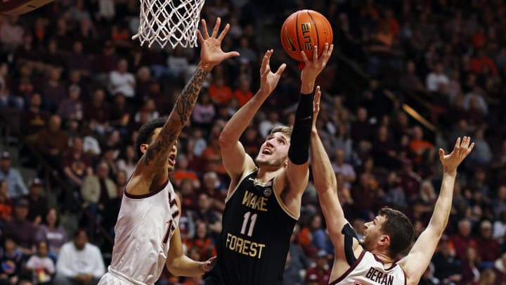 Mar 2, 2024; Blacksburg, Virginia, USA; Wake Forest Demon Deacons forward Andrew Carr (11) shoots the ball against Virginia Tech Hokies forward Robbie Beran (31) and Virginia Tech Hokies center Lynn Kidd (15) during the first half at Cassell Coliseum. Mandatory Credit: Peter Casey-USA TODAY Sports