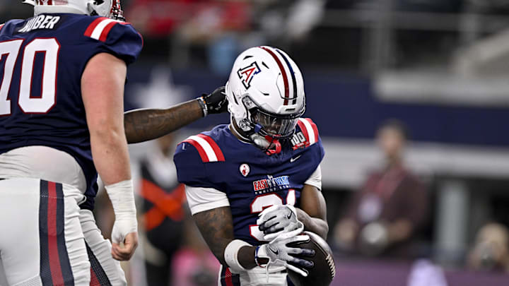 East running back Jacory Croskey-Merritt of Arizona and East offensive lineman Joe Huber of Wisconsin.