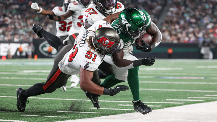 Aug 19, 2023; East Rutherford, New Jersey, USA; New York Jets running back Israel Abanikanda (25) is tackled by Tampa Bay Buccaneers linebacker J.J. Russell (51) and linebacker Ulysees Gilbert (57) during the second half at MetLife Stadium.  