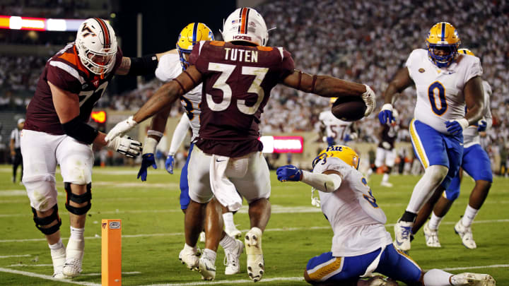 Sep 30, 2023; Blacksburg, Virginia, USA; Virginia Tech Hokies running back Bhayshul Tuten (33) scores a touchdown during the second quarter against Pittsburgh Panthers defensive back Donovan McMillon (3) at Lane Stadium. Mandatory Credit: Peter Casey-USA TODAY Sports