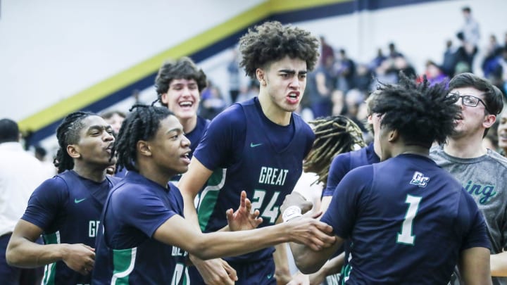 Great Crossing's Malachi Moreno (24) and teammates mob Vince Dawson (1) in jubilation after Dawson's last second shot lifted the Warhawks 48-46 over Newport at Thursday's 2023 Chad Gardner Law King of the Bluegrass holiday basketball tournament at Fairdale High School. Dec. 21, 2023