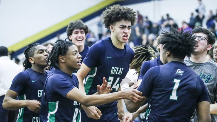 Great Crossing's Malachi Moreno (24) and teammates mob Vince Dawson (1) in jubilation after Dawson's last second shot lifted the Warhawks 48-46 over Newport at Thursday's 2023 Chad Gardner Law King of the Bluegrass holiday basketball tournament at Fairdale High School. Dec. 21, 2023