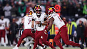 Washington Commanders quarterback Jayden Daniels hands off the ball to running back Brian Robinson Jr.