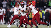 Washington Commanders quarterback Jayden Daniels hands off the ball to Brian Robinson Jr. against the Philadelphia Eagles