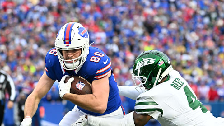 Dec 29, 2024; Orchard Park, New York, USA; Buffalo Bills tight end Dalton Kincaid (86) tries to break free from New York Jets cornerback D.J. Reed (4) after a catch in the first quarter at Highmark Stadium. Mandatory Credit: Mark Konezny-Imagn Images
