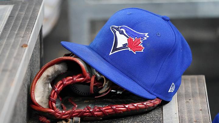 Apr 16, 2025; Toronto, Ontario, CAN; A Toronto Blue Jays hat and glove in the dugout during a game against the Atlanta Braves at Rogers Centre. Mandatory Credit: John E. Sokolowski-Imagn Images