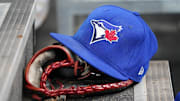 Apr 16, 2025; Toronto, Ontario, CAN; A Toronto Blue Jays hat and glove in the dugout during a game against the Atlanta Braves at Rogers Centre. Mandatory Credit: John E. Sokolowski-Imagn Images