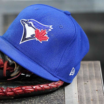 Apr 16, 2025; Toronto, Ontario, CAN; A Toronto Blue Jays hat and glove in the dugout during a game against the Atlanta Braves at Rogers Centre. Mandatory Credit: John E. Sokolowski-Imagn Images