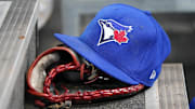 Apr 16, 2025; Toronto, Ontario, CAN; A Toronto Blue Jays hat and glove in the dugout during a game against the Atlanta Braves at Rogers Centre. Mandatory Credit: John E. Sokolowski-Imagn Images