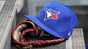 Apr 16, 2025; Toronto, Ontario, CAN; A Toronto Blue Jays hat and glove in the dugout during a game against the Atlanta Braves at Rogers Centre. Mandatory Credit: John E. Sokolowski-Imagn Images