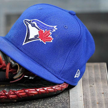 Apr 16, 2025; Toronto, Ontario, CAN; A Toronto Blue Jays hat and glove in the dugout during a game against the Atlanta Braves at Rogers Centre.