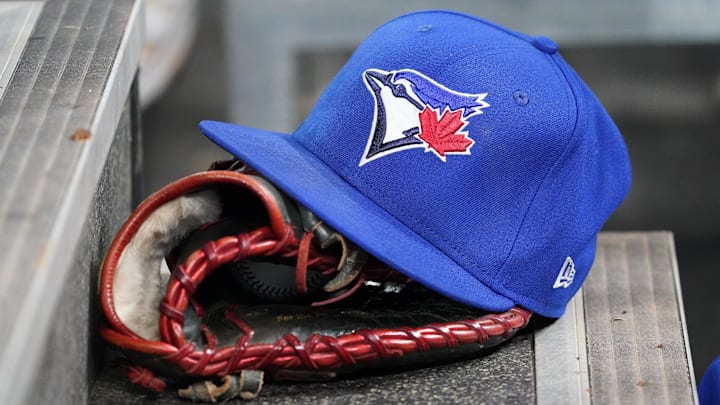 Apr 16, 2025; Toronto, Ontario, CAN; A Toronto Blue Jays hat and glove in the dugout during a game against the Atlanta Braves at Rogers Centre. 