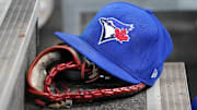Apr 16, 2025; Toronto, Ontario, CAN; A Toronto Blue Jays hat and glove in the dugout during a game against the Atlanta Braves at Rogers Centre. 