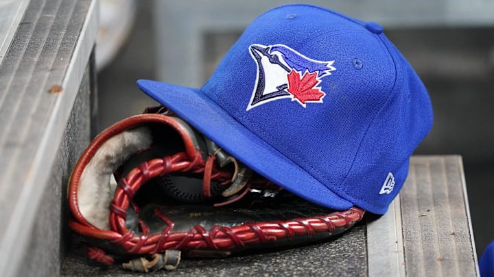 Apr 16, 2025; Toronto, Ontario, CAN; A Toronto Blue Jays hat and glove in the dugout during a game against the Atlanta Braves at Rogers Centre. Mandatory Credit: John E. Sokolowski-Imagn Images