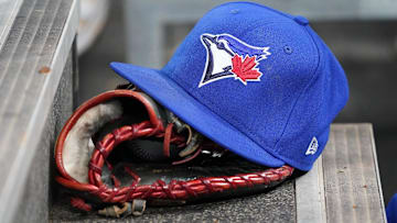 Apr 16, 2025; Toronto, Ontario, CAN; A Toronto Blue Jays hat and glove in the dugout during a game against the Atlanta Braves at Rogers Centre.