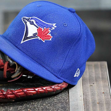 Apr 16, 2025; Toronto, Ontario, CAN; A Toronto Blue Jays hat and glove in the dugout during a game against the Atlanta Braves at Rogers Centre.