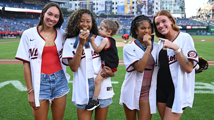 Aug 28, 2024; Washington, District of Columbia, USA; Olympic gold medalist swimmer Tori Huske and Washington Spirit soccer players Casey Krueger, Croix Bethune and Hal Hershfelt pose for a photo with their medals before a game between the Washington Nationals and the New York Yankees at Nationals Park. 