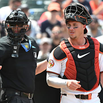 Jul 14, 2024; Baltimore, Maryland, USA;  Baltimore Orioles catcher James McCann (27) and umpire Emil Jimenez (82) look towards the dugout during the eighth inning against the New York Yankees at Oriole Park at Camden Yards.