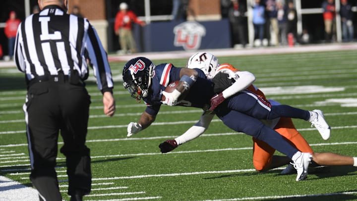 Nov 19, 2022; Lynchburg, Virginia, USA; Liberty Flames wide receiver Demario Douglas (3) catches ball as Virginia Tech Hokies defensive back Mansoor Delane (23) makes tackle at Williams Stadium. Mandatory Credit: Lee Luther Jr.-Imagn Images