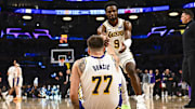 Nov 2, 2025; Los Angeles, California, USA; Los Angeles Lakers guard Bronny James (9) helps guard Luka Doncic (77) up from the floor against the Miami Heat during the second half at Crypto.com Arena. Mandatory Credit: Jonathan Hui-Imagn Images
