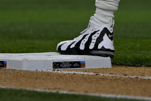 Deion Sanders wears white and black Nike sneakers.