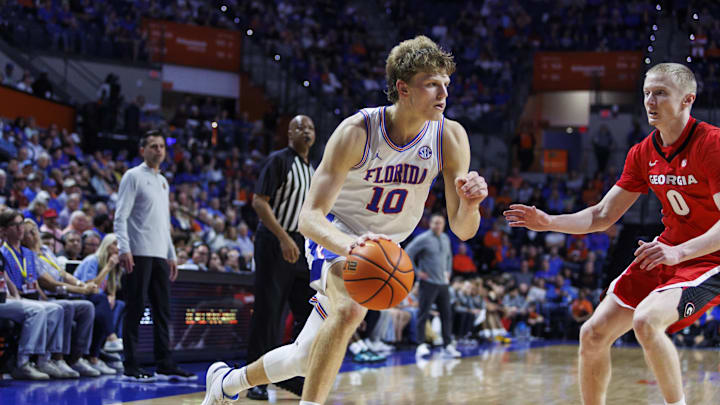Jan 6, 2026; Gainesville, Florida, USA; Florida Gators forward Thomas Haugh (10) dribbles the ball past Georgia Bulldogs guard Blue Cain (0) during the second half at Exactech Arena at the Stephen C. O'Connell Center. Mandatory Credit: Morgan Tencza-Imagn Images