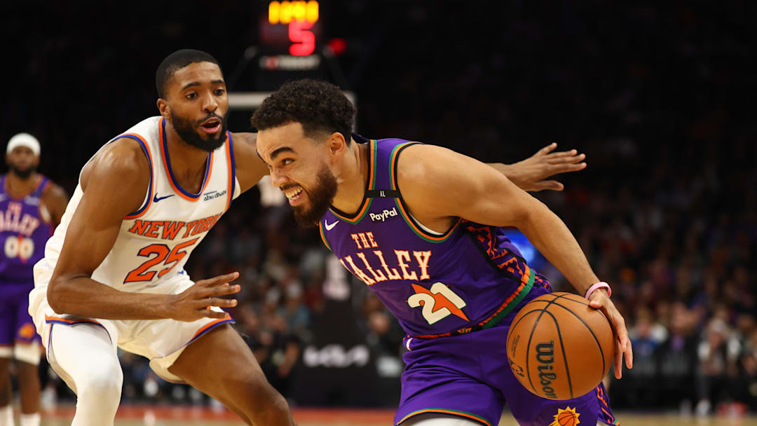 Nov 20, 2024; Phoenix, Arizona, USA; Phoenix Suns guard Tyus Jones (21) against New York Knicks forward Mikal Bridges (25) at Footprint Center. Mandatory Credit: Mark J. Rebilas-Imagn Images