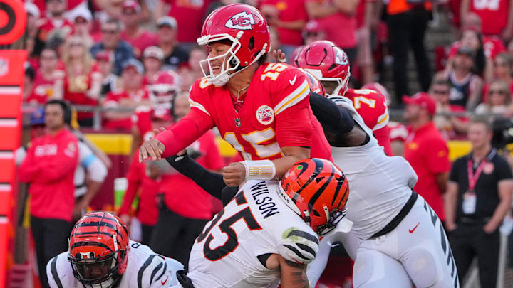 Sep 15, 2024; Kansas City, Missouri, USA; Kansas City Chiefs quarterback Patrick Mahomes (15) is hit by Cincinnati Bengals linebacker Logan Wilson (55) while throwing a pass during the second half at GEHA Field at Arrowhead Stadium. Mandatory Credit: Denny Medley-Imagn Images