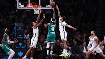 Nov 13, 2024; Brooklyn, New York, USA; Boston Celtics guard Jrue Holiday (4) shoots the ball as Brooklyn Nets guard Keon Johnson (45) and forward Noah Clowney (21) defend during the second half at Barclays Center. Mandatory Credit: Vincent Carchietta-Imagn Images