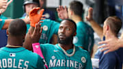 Sep 16, 2025; Kansas City, Missouri, USA; Seattle Mariners left fielder Randy Arozarena (56) is congratulated by teammates after scoring a run in the first inning against the Kansas City Royals at Kauffman Stadium. Mandatory Credit: Scott Sewell-Imagn Images