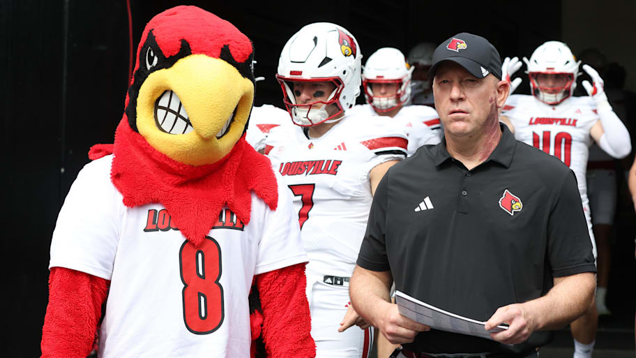 Louisville head coach Jeff Brohm (right) leads the team onto the field to play Pittsburgh