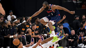 Oct 24, 2025; Inglewood, California, USA; Los Angeles Clippers guard James Harden (1) jumps over Phoenix Suns forward Oso Ighodaro (11) as he goes for a loose ball in the first half at Intuit Dome. Mandatory Credit: Jayne Kamin-Oncea-Imagn Images