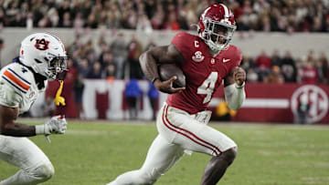 Nov 30, 2024; Tuscaloosa, Alabama, USA;  Alabama Crimson Tide quarterback Jalen Milroe (4) runs for a touchdown against Auburn Tigers cornerback Kayin Lee (4) during the second half at Bryant-Denny Stadium. Alabama won 28-14. Mandatory Credit: Gary Cosby Jr.-Imagn Images