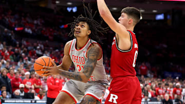 Dec 7, 2024; Columbus, Ohio, USA;  Ohio State Buckeyes forward Devin Royal (21) goes up for the basket as Rutgers Scarlet Knights guard Jordan Derkack (0) defends during the second half at Value City Arena. Mandatory Credit: Joseph Maiorana-Imagn Images