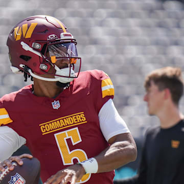 Aug 10, 2024; East Rutherford, New Jersey, USA; Washington Commanders quarterback Jayden Daniels (5) warms up before the game against the New York Jets at MetLife Stadium. Mandatory Credit: Lucas Boland-Imagn Images