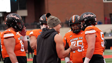Oklahoma State Offensive Line coach Cooper Bassett talks with players before the college football game between the Oklahoma State Cowboys and the Iowa State Cyclones at Boone Pickens Stadium in Stillwater, Okla., Saturday Nov. 29, 2025.