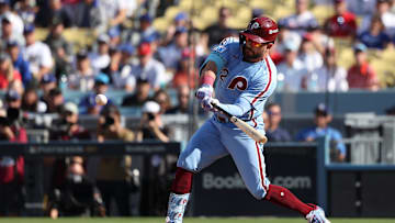 Oct 9, 2025; Los Angeles, California, USA; Philadelphia Phillies left fielder Kyle Schwarber (12) doubles in the first inning against the Los Angeles Dodgers during game four of the NLDS round for the 2025 MLB playoffs at Dodger Stadium. Mandatory Credit: Kiyoshi Mio-Imagn Images