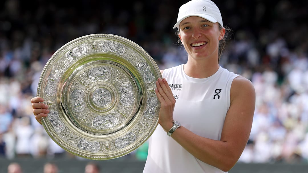 Iga Swiatek proudly holds the Wimbledon women's singles trophy.