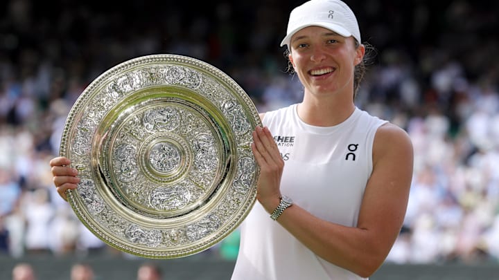 Iga Swiatek proudly holds the Wimbledon women's singles trophy.