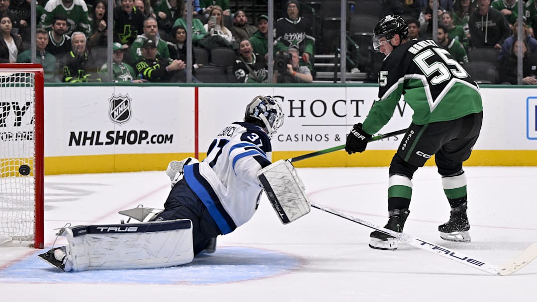Feb 2, 2026; Dallas, Texas, USA; Dallas Stars defenseman Thomas Harley (55) scores the game winning goal against Winnipeg Jets goaltender Connor Hellebuyck (37) during the overtime period at the American Airlines Center. Mandatory Credit: Jerome Miron-Imagn Images