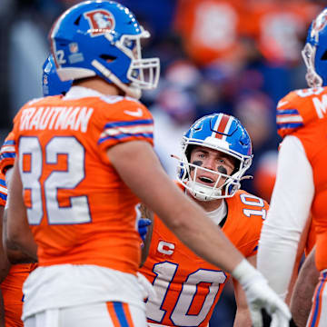 Jan 5, 2025; Denver, Colorado, USA; Denver Broncos quarterback Bo Nix (10) huddles with tight end Adam Trautman (82) and offensive tackle Mike McGlinchey (69) and teammates in the third quarter against the Kansas City Chiefs at Empower Field at Mile High. 