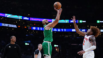 Oct 22, 2024; Boston, Massachusetts, USA; Boston Celtics guard Derrick White (9) makes a three-point basket against New York Knicks guard Miles McBride (2) in the second quarter at TD Garden. Mandatory Credit: David Butler II-Imagn Images
