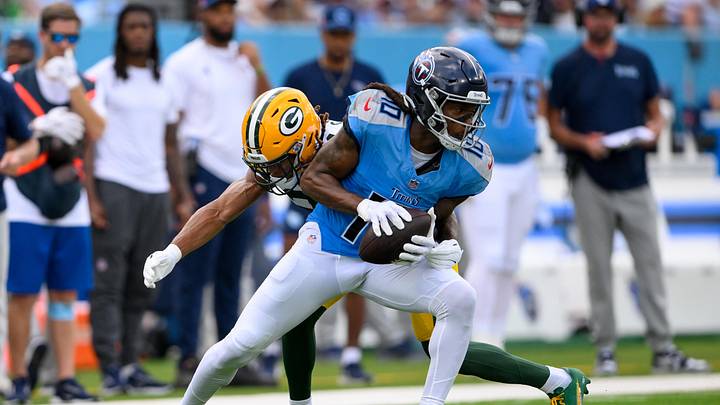 Sep 22, 2024; Nashville, Tennessee, USA;  Green Bay Packers cornerback Eric Stokes (21) tackles Tennessee Titans wide receiver DeAndre Hopkins (10) after a made catch during the first half at Nissan Stadium. Mandatory Credit: Steve Roberts-Imagn Images