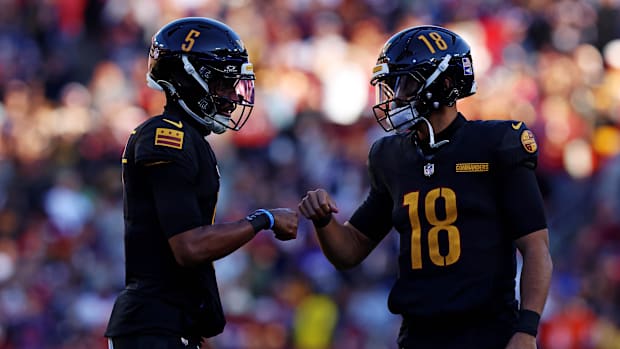 Washington Commanders quarterback Jayden Daniels (5) and quarterback Marcus Mariota (18) talk to each other