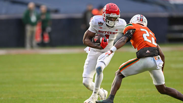Dec 28, 2023; Bronx, NY, USA; Rutgers Scarlet Knights wide receiver Famah Toure (1) runs with the ball after a catch chased by Miami Hurricanes defensive back Jaden Davis (22) during the second quarter at Yankee Stadium. Mandatory Credit: Mark Smith-Imagn Images