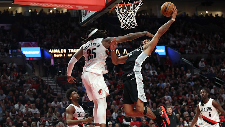 Spurs guard Dylan Harper goes up for a dunk over Trail Blazers center Robert Williams III.