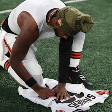 Nov 9, 2025; East Rutherford, New Jersey, USA; Cleveland Browns quarterback Shedeur Sanders (12) signs his jersey on the field after the game against the New York Jets at MetLife Stadium. Mandatory Credit: Vincent Carchietta-Imagn Images
