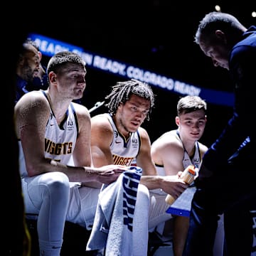 Denver Nuggets center Nikola Jokic (15) and forward Aaron Gordon (50) and guard Christian Braun (0) look on as head coach Michael Malone talks during a timeout in the first quarter against the Memphis Grizzlies at Ball Arena. 